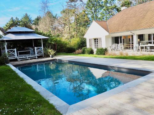 une piscine dans la cour d'une maison dans l'établissement Villa avec piscine au coeur de la forêt, à Le Touquet-Paris-Plage