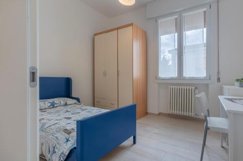 Schlafzimmer mit einem blauen Bett und einem Schreibtisch in der Unterkunft Spacious Apartment x5 with two balconies! in Bologna