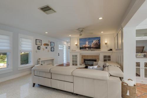 a living room with a white couch and a fireplace at Surfs Up - Retreat At The Beach With Heated Pool in Melbourne Beach