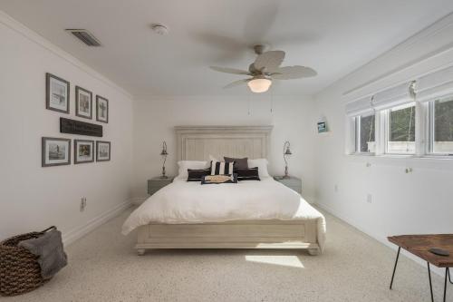 a white bedroom with a bed and a ceiling fan at Surfs Up - Retreat At The Beach With Heated Pool in Melbourne Beach