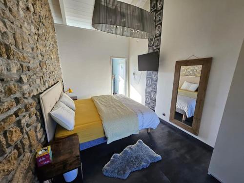 een slaapkamer met een bed en een stenen muur bij Villa avec piscine à 10 min des plages in Olonne-sur-Mer
