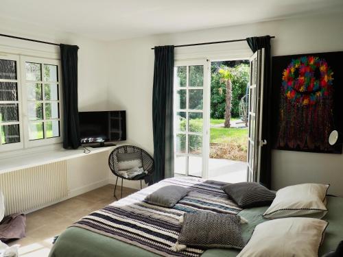 Schlafzimmer mit einem Bett und einer Glasschiebetür in der Unterkunft Villa avec piscine au coeur de la forêt in Le Touquet-Paris-Plage