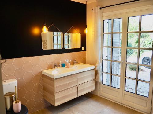 ein Bad mit einem Waschbecken und einem Fenster in der Unterkunft Villa avec piscine au coeur de la forêt in Le Touquet-Paris-Plage