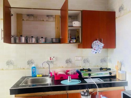 a kitchen counter with a sink and a stove at Paradise in Dar es Salaam