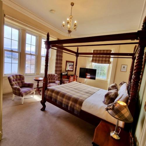 a bedroom with a canopy bed and a table and chairs at Loch Maree Hotel in Talladale