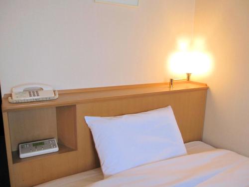 Un pat sau paturi într-o cameră la Hotel Crown Hills Kofu