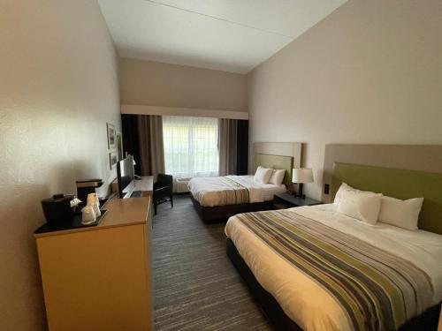 a hotel room with two beds and a television at Country Inn & Suites by Radisson, Knoxville West, TN in Knoxville