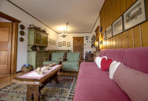 a living room with a pink couch and a table at Villa Aurora in Pocol