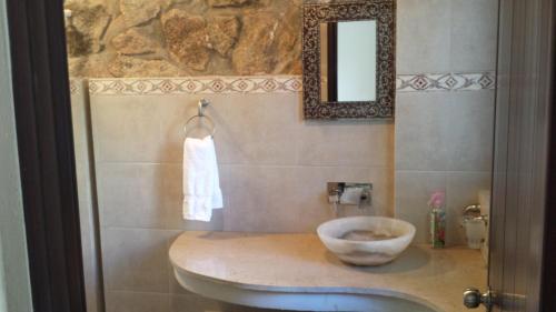 a bathroom with a sink and a mirror at Villa Costa Chica Comodisimo piscina gigante jardines in Acapulco