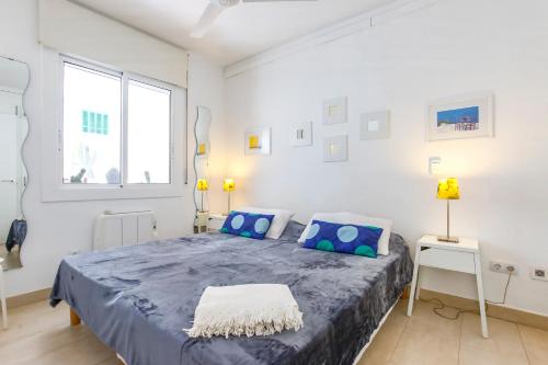1 dormitorio con 1 cama grande con almohadas azules en CUBAN GREEN Terrace en Sitges