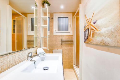 y baño con lavabo blanco y espejo. en CUBAN GREEN Terrace en Sitges
