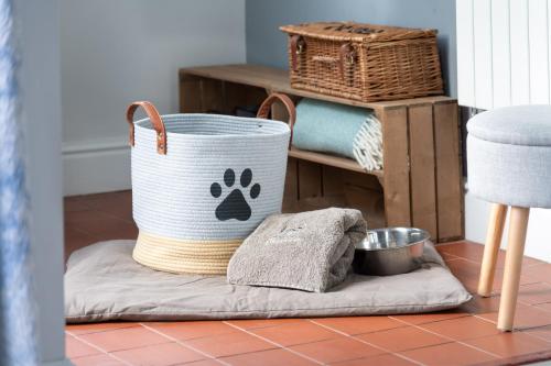 una cesta en el suelo con una toalla de pata de perro en Marys Cottage, Grasmere, Dog Friendly, Hot Tub, en Grasmere