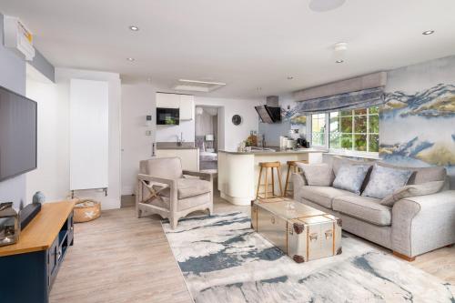 a living room with a couch and a kitchen at Marys Cottage, Grasmere, Dog Friendly, Hot Tub in Grasmere
