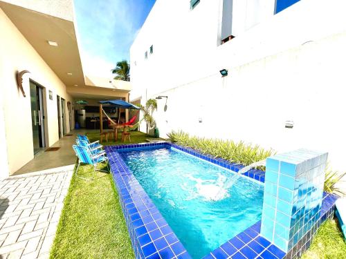 a swimming pool in the backyard of a house at Casa Conchas do Patacho in Pôrto de Pedras
