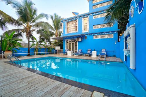 a blue house with a swimming pool at Lacasita Villas & Cottages near Anjuna Beach & Shiva Valley in Anjuna