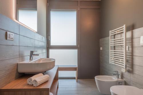 ein Bad mit einem Waschbecken, 2 WCs und einem Fenster in der Unterkunft Unico Studios in Mailand