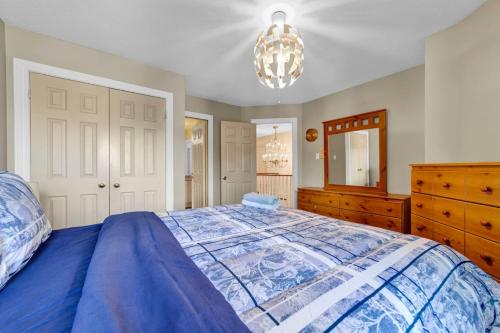 een slaapkamer met een bed, een dressoir en een kroonluchter bij Individual Bedroom - Charming Private Room and Ensuite in Shared Home in Mississauga