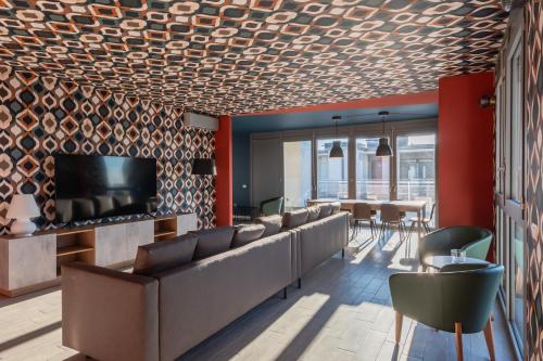 a lobby with couches and a television and a table at Unico Studios in Milan
