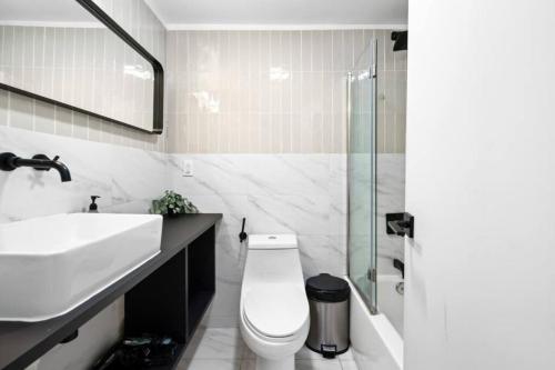 een badkamer met een toilet, een wastafel en een douche bij Sleek Modern 2BR in Bed-Stuy Brooklyn in Brooklyn