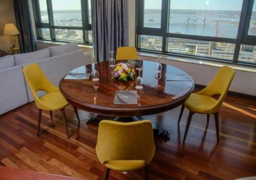 a dining room with a table and yellow chairs at Radisson Montevideo Victoria Plaza Hotel in Montevideo