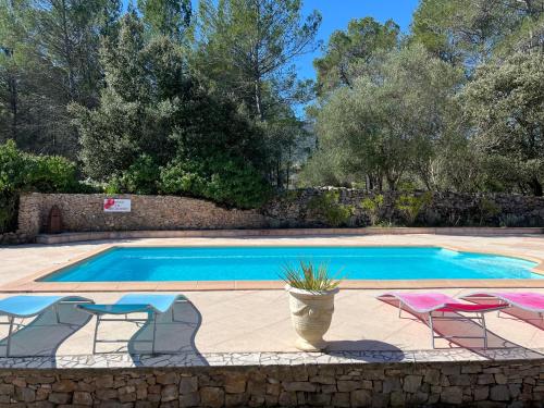 uma piscina com duas cadeiras e uma mesa em Villa Conception em Le Thoronet
