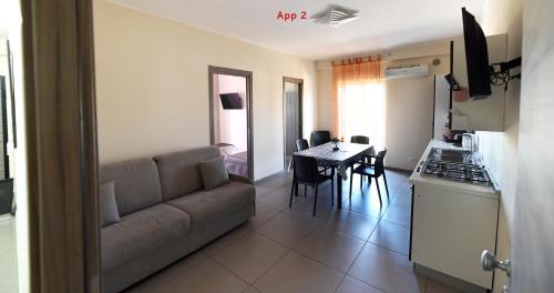 a living room with a couch and a table and a kitchen at Le Case Di Nonna Angela in Matera