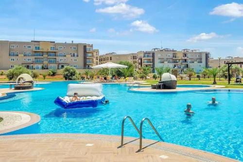 Una piscina en un resort con gente en el agua. en 2+1 in Cyprus Thalassa Beach Resort, en Vokolidha