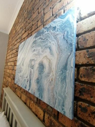 a painting hanging on a brick wall at Shingalana Guest Lodge in Hazyview