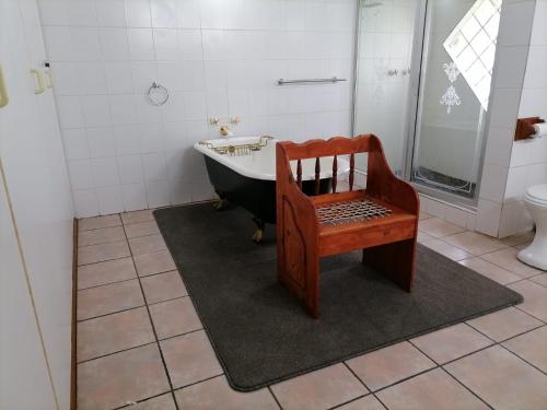 a bathroom with a tub and a chair and a sink at Shingalana Guest Lodge in Hazyview