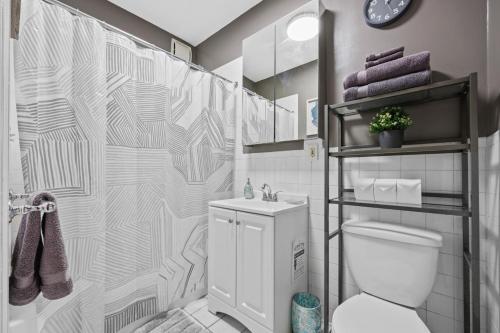 a bathroom with a toilet and a shower curtain at 1BR Brownstone w Rare Outdoor Space in New York