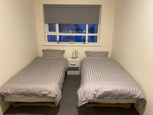 A bed or beds in a room at Húsavík 2 Bedroom Apartment