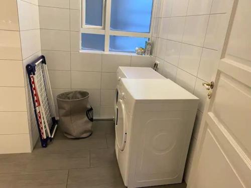 uma máquina de lavar roupa branca na casa de banho com uma janela em Húsavík 2 Bedroom Apartment em Húsavík
