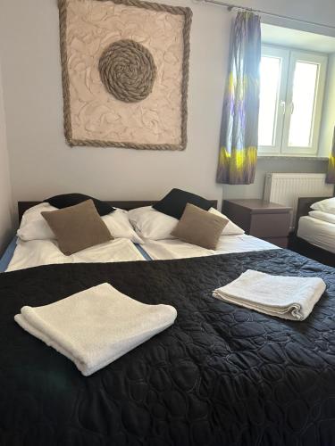 - 2 lits dans une chambre avec des serviettes sur un lit dans l'établissement APARTAMENT NAD KAMIEŃCZYKIEM II, à Szklarska Poręba