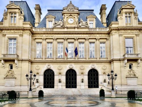 un bâtiment avec une horloge sur la façade dans l'établissement Neuilly Sablons, à Neuilly-sur-Seine