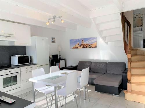 une cuisine et un salon avec une table et un canapé dans l'établissement Maisonnette bretonne 100m de la mer avec jardin à TREGASTEL - Réf 18, à Trégastel