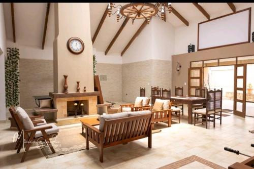 a living room with a fireplace and tables and chairs at Casa - Villa Real de Aragón in Cochabamba