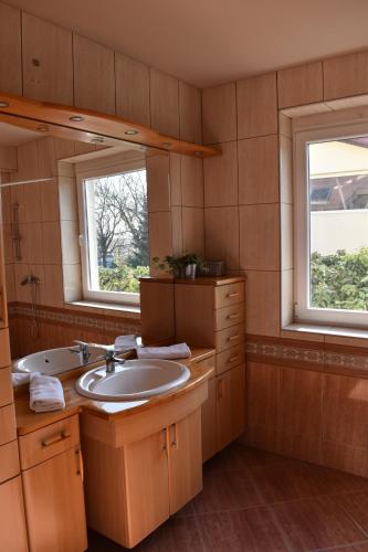 a bathroom with a sink and two windows at Partyház Gödöllő in Gödöllő