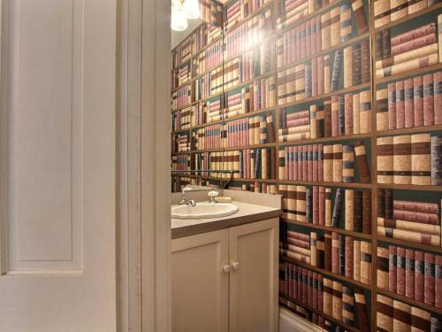 a bathroom with a sink and a wall of books at Washington Square Manor in Savannah