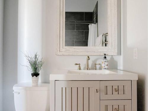 Un baño con lavabo, inodoro y espejo. en Stadium Lofts on Meridian #3, en Indianápolis