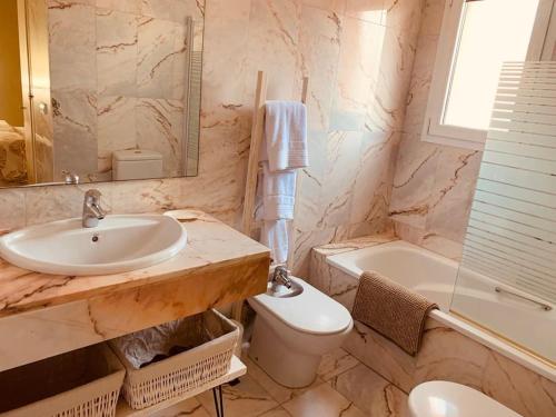 a bathroom with a sink and a toilet and a tub at Exclusivo ático frente al Mar en s'Agaró in Girona