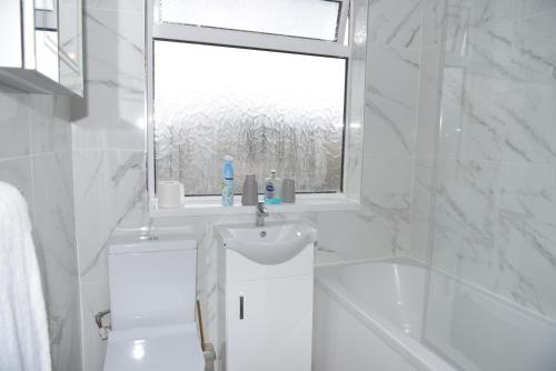 a white bathroom with a sink and a window at brook house in London