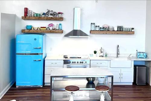 a kitchen with a blue refrigerator and white cabinets at Stadium Lofts on Meridian #4 in Indianapolis