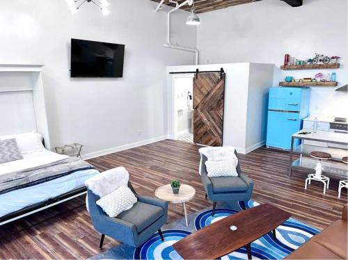 a bedroom with a bed and two chairs and a table at Stadium Lofts on Meridian #4 in Indianapolis