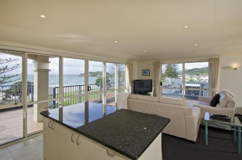 a living room with a couch and a television at Pavilion Beachfront Apartments in Mount Maunganui