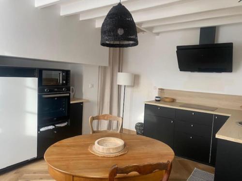 una cucina con tavolo in legno e una sala da pranzo di YVECRIQUE - Maison avec Jardin tout confort 2 à 6 pers 