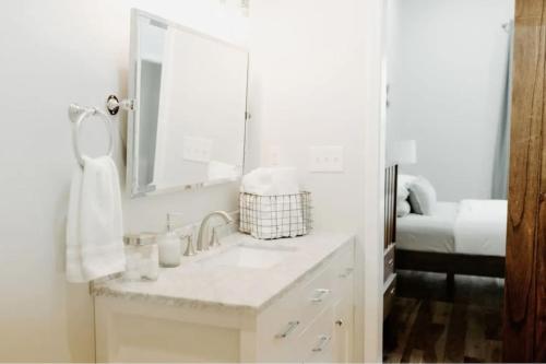 a white bathroom with a sink and a mirror at Stadium Lofts on Meridian #2 in Indianapolis