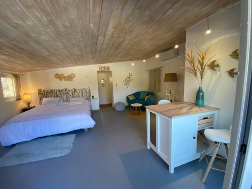 1 dormitorio con cama y techo de madera en D’ici et d’ailleurs, en Beaumont-de-Pertuis