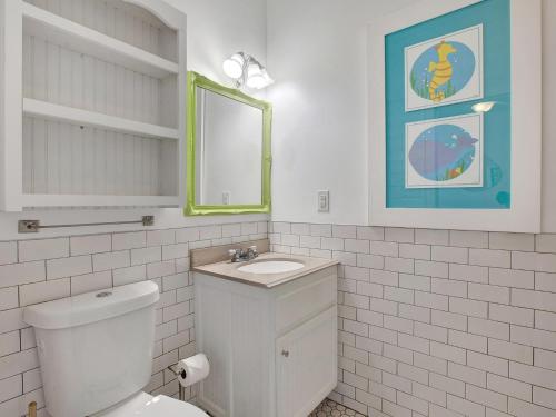 een witte badkamer met een toilet en een wastafel bij Beach Walk 4 in Tybee Island