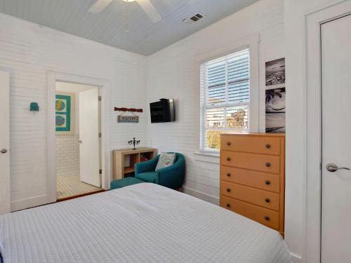 een slaapkamer met een bed, een stoel en een televisie bij Beach Walk 4 in Tybee Island