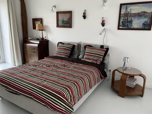 - une chambre avec un lit avec une couverture rayée et une table dans l'établissement Villa avec jardin à 370m de la plage de Landrellec à PLEUMEUR-BODOU REF-245, à Pleumeur-Bodou